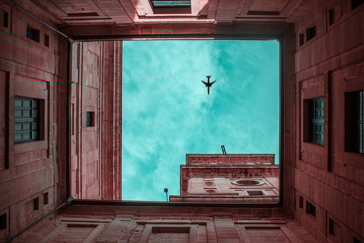 plane flying over building